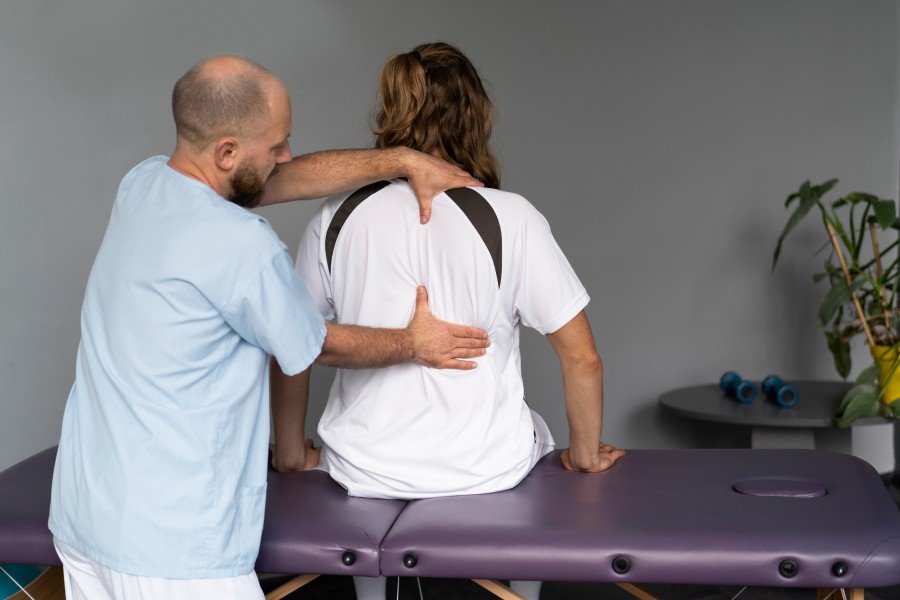 Physiotherapist providing manual therapy for upper back and shoulder pain