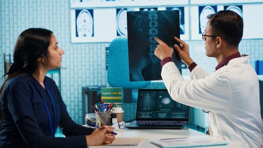 Doctor explaining an X-ray to a patient during a Slip disc treatment consultation.